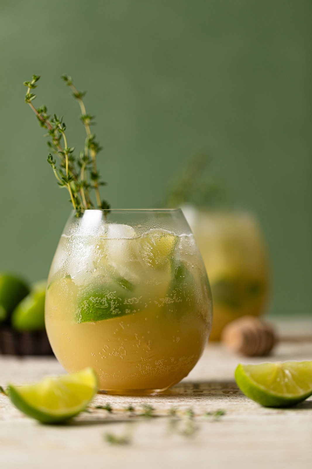 Glass of Simple Lime Rickey Mocktail with thyme and lime wedges