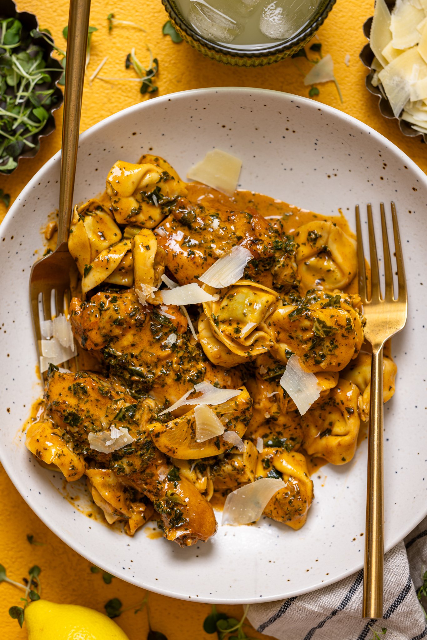 Creamy Lemon Garlic Herb Chicken with Tortellini on a plate with two forks.