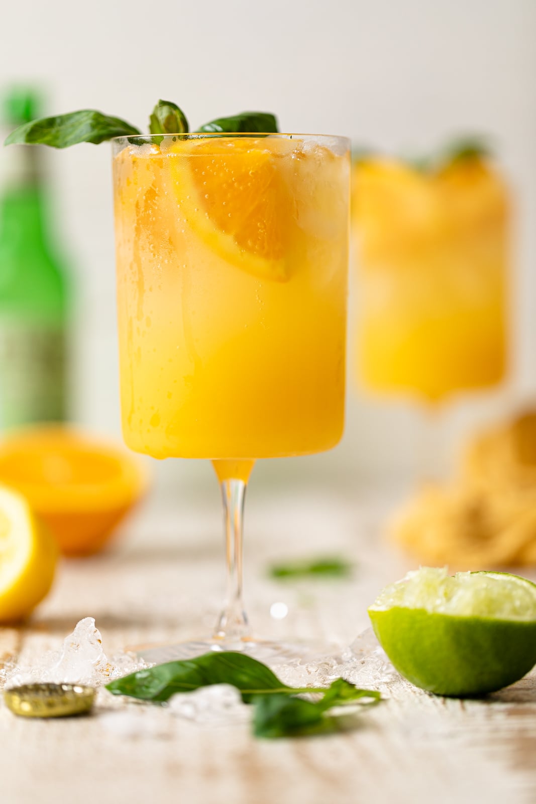 Bright Orange Crush Mocktail with Basil topped with basil leaves