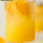 Closeup of a bright Orange Crush Mocktail with Basil
