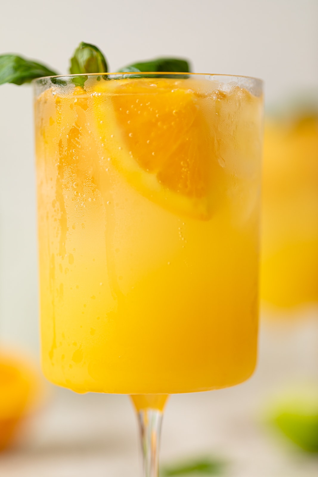 Closeup of a bright Orange Crush Mocktail with Basil