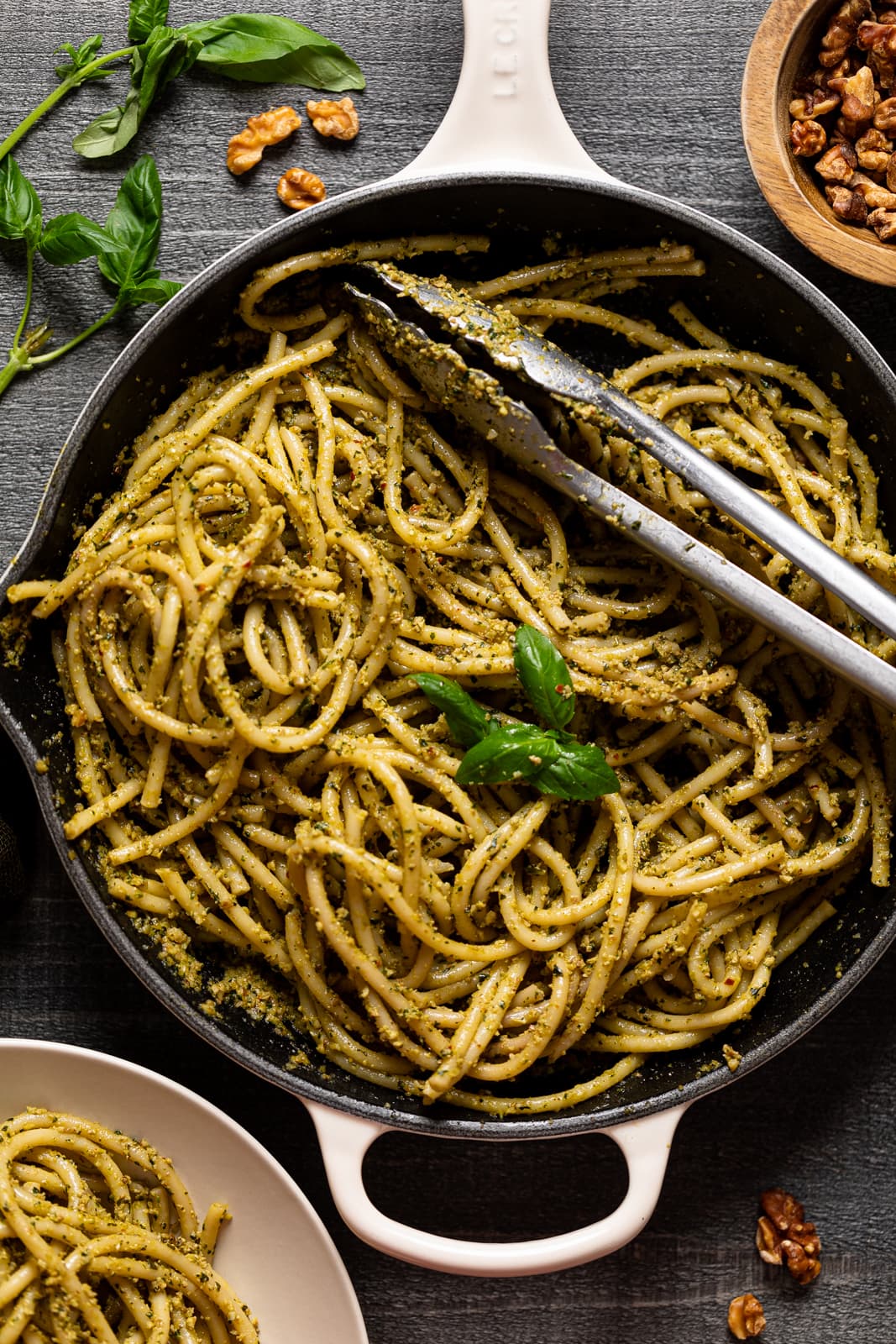 Tongs lying across a skillet of Walnut Pesto Bucatini Pasta