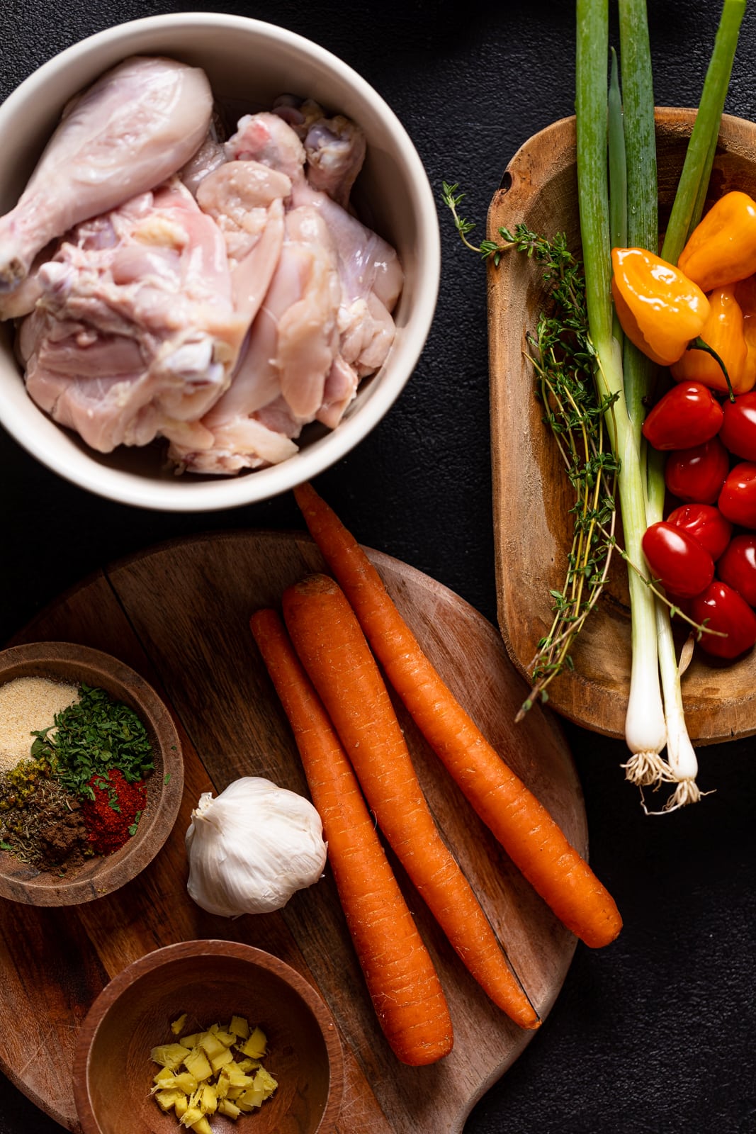 Ingredients for Jamaican Brown Stew Chicken including tomatoes, peppers, green onions, and carrots