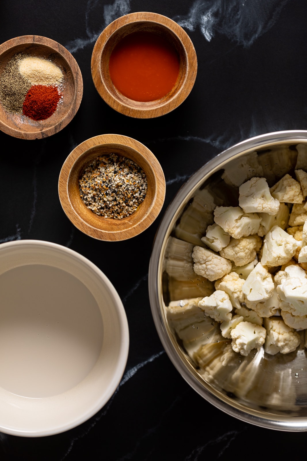 Ingredients for Everything Bagel Cauliflower Bites including chopped cauliflower, everything bagel seasoning, and spices