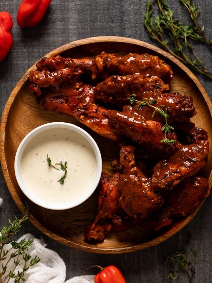 Oven Baked Buffalo Wings on a wooden plate with a small bowl of dip