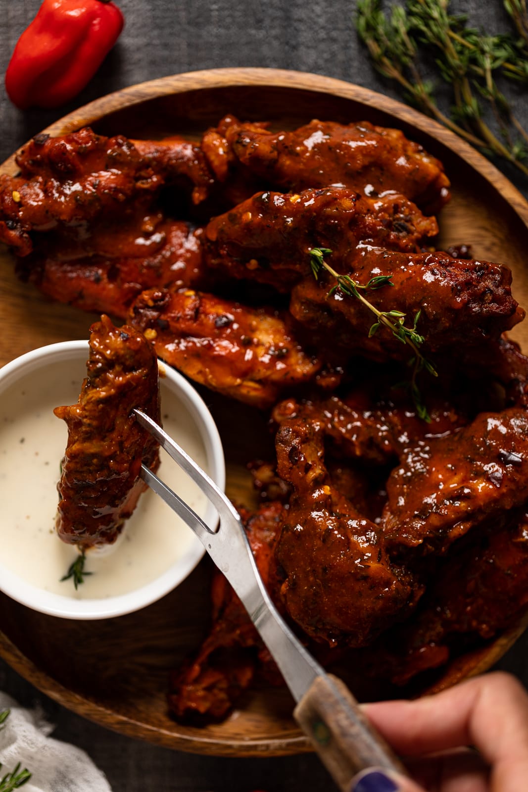 Two-pronged fork dipping a buffalo wing