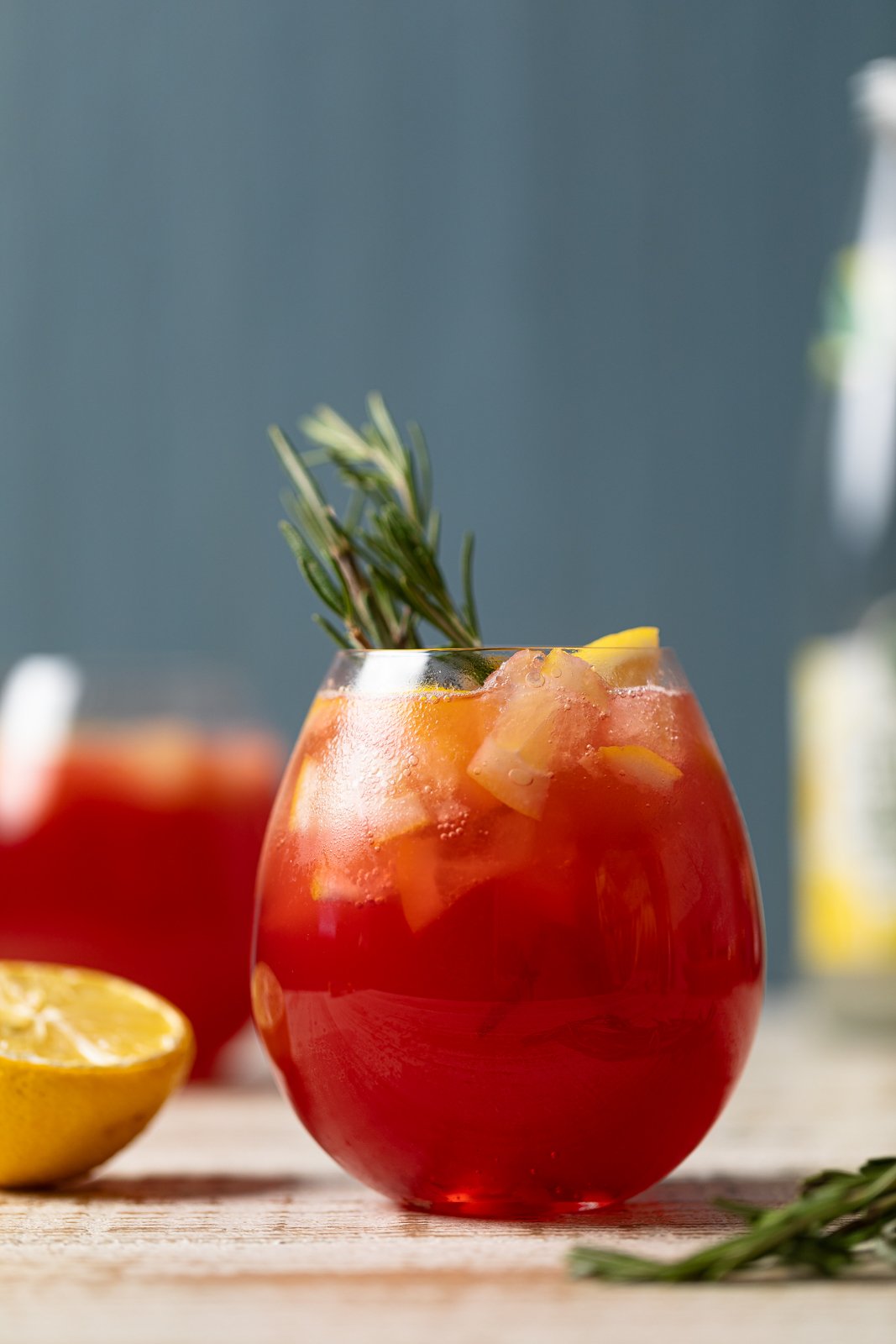Cranberry Lemon Spritzer with Lemonade Ice Cubes topped with sprigs of rosemary