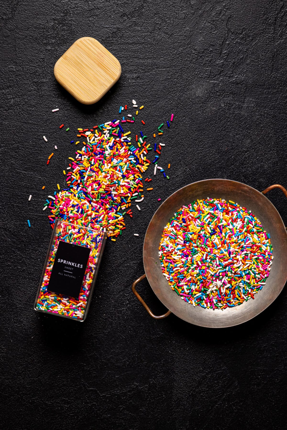 Bowl of sprinkles and a spilled jar of sprinkles