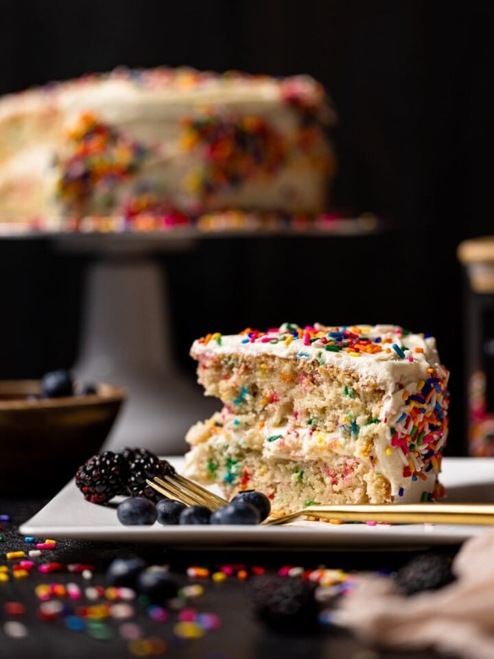 Slice of Vegan Funfetti Cake with Vanilla Buttercream on a plate