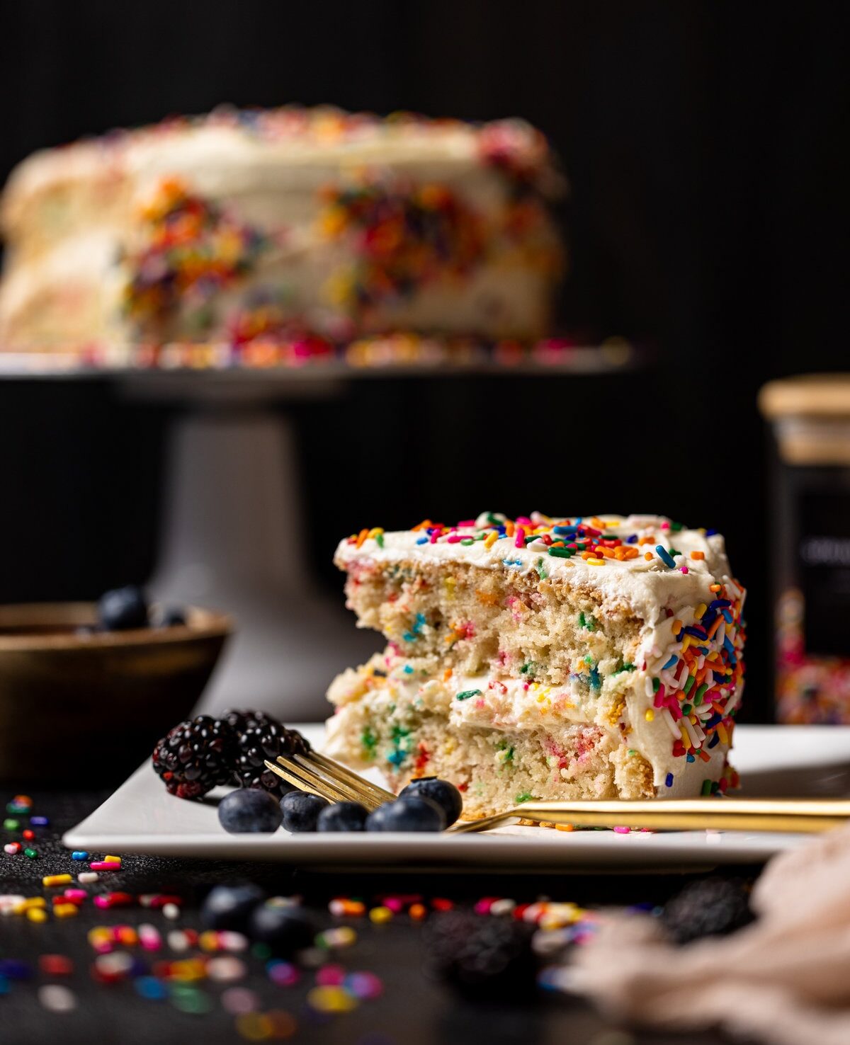 Slice of Vegan Funfetti Cake with Vanilla Buttercream on a plate