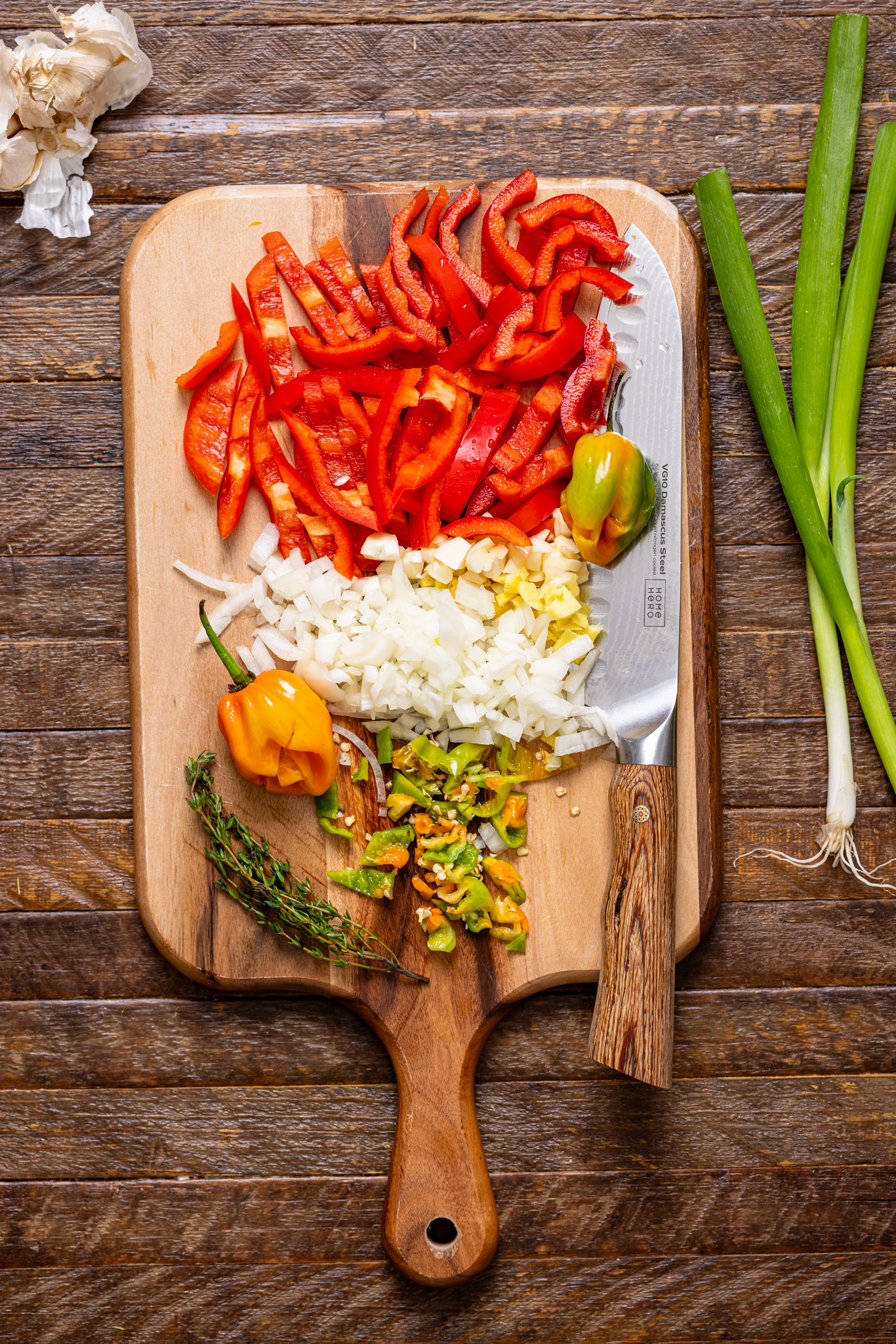 Chopped veggies on a cutting board with a knife.