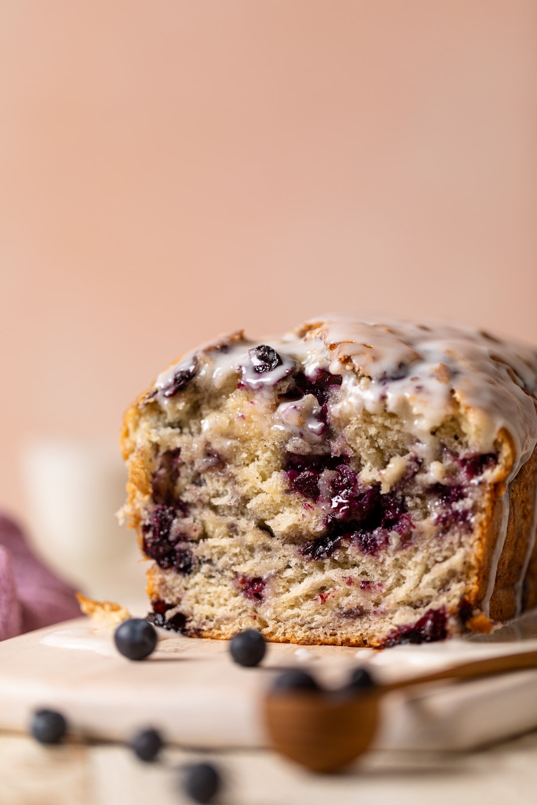 Loaf of Roasted Blueberry Lemon Olive Oil Bread with the end sliced off on a plate