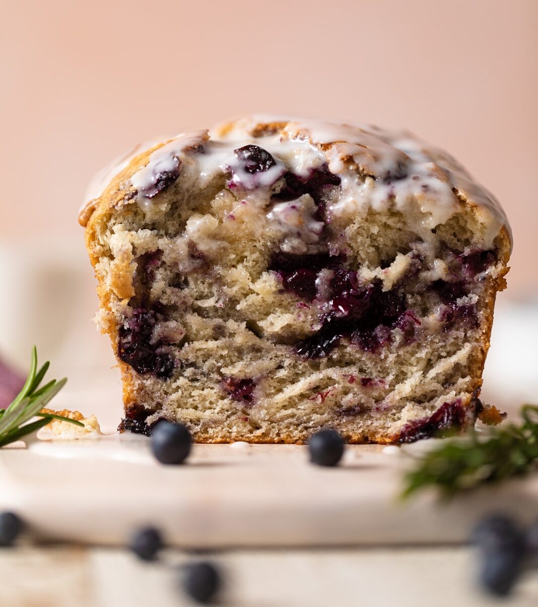 Loaf of Roasted Blueberry Lemon Olive Oil Bread with the end sliced off on a plate