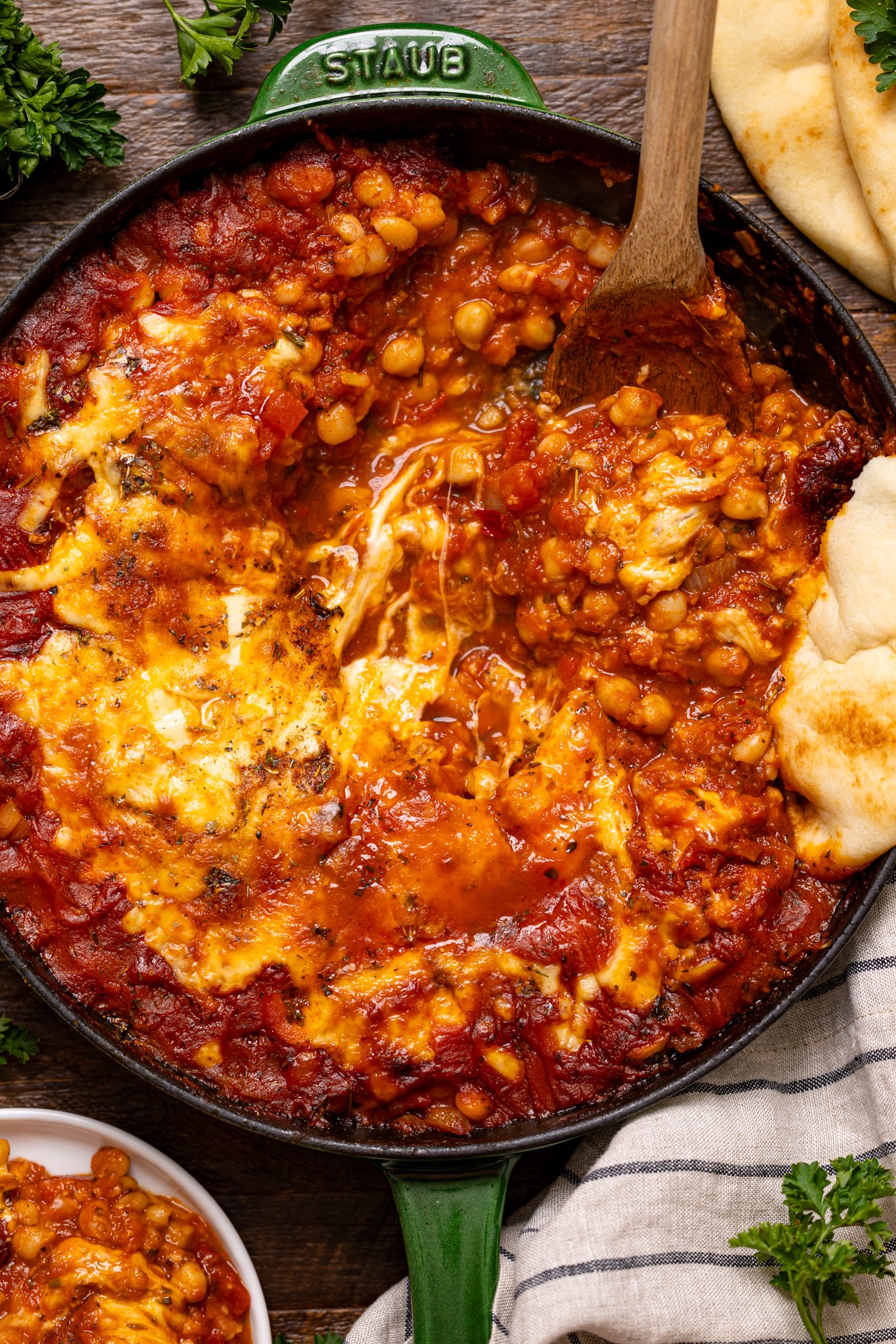 One-Pot Chickpeas and White Beans in a skillet with wooden spoon and garnish.