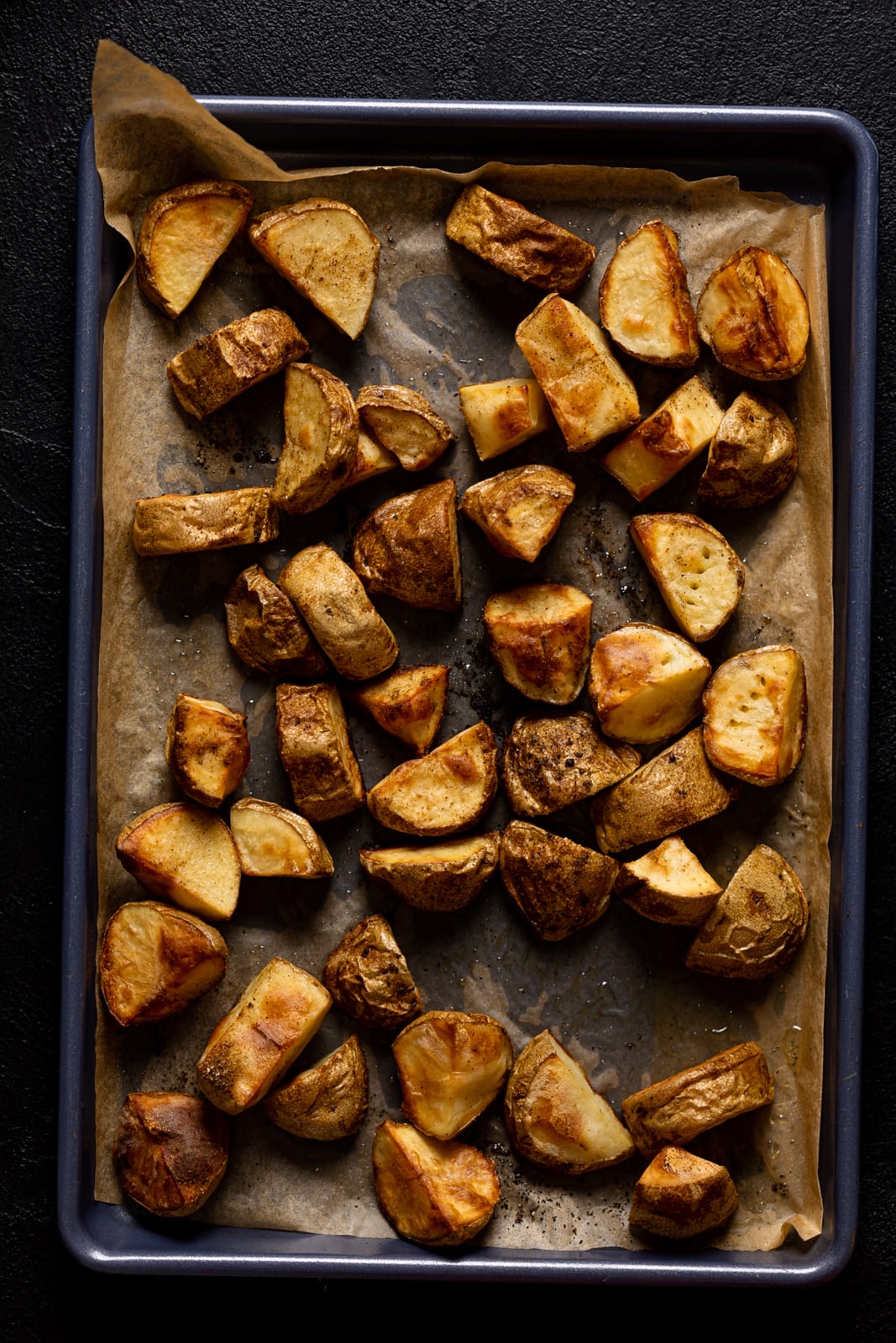 Roasted potato pieces on a baking sheet