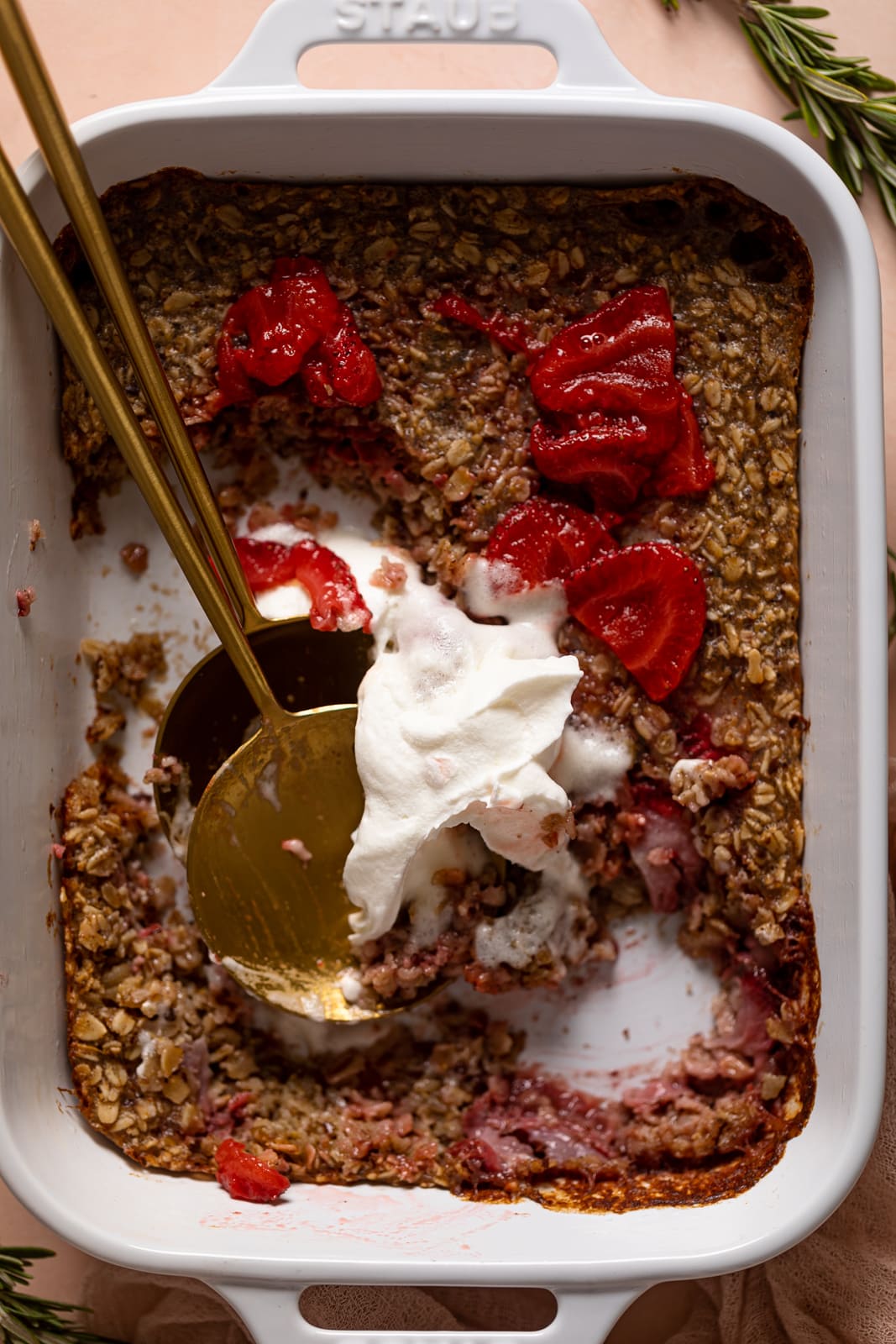 Closeup of Strawberry Shortcake Baked Oats topped with strawberry sauce and coconut whipped cream