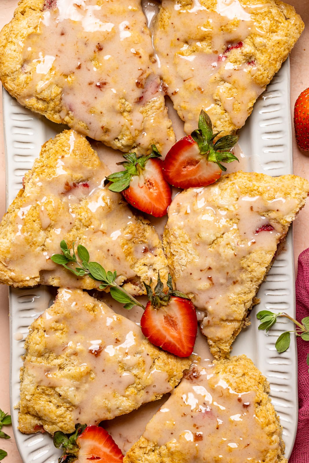 Up close shot of scones with strawberries and herbs.