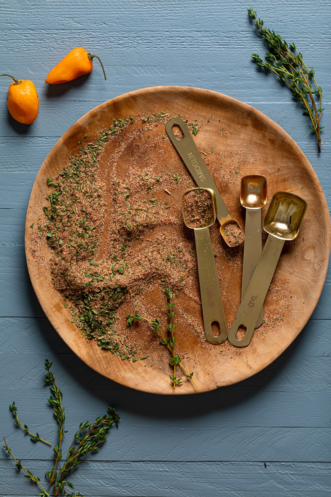 Seasonings and measuring spoons on a wooden plate