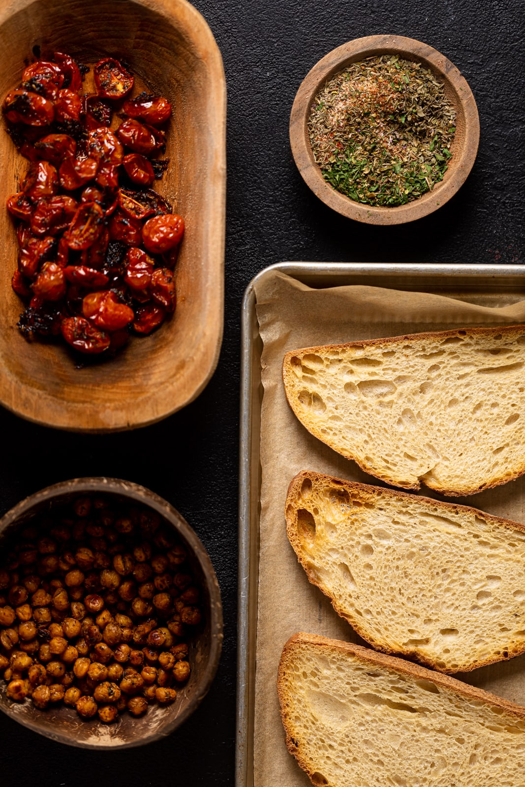 Ingredients for Avocado Toast including roasted tomatoes, chickpeas, and bread