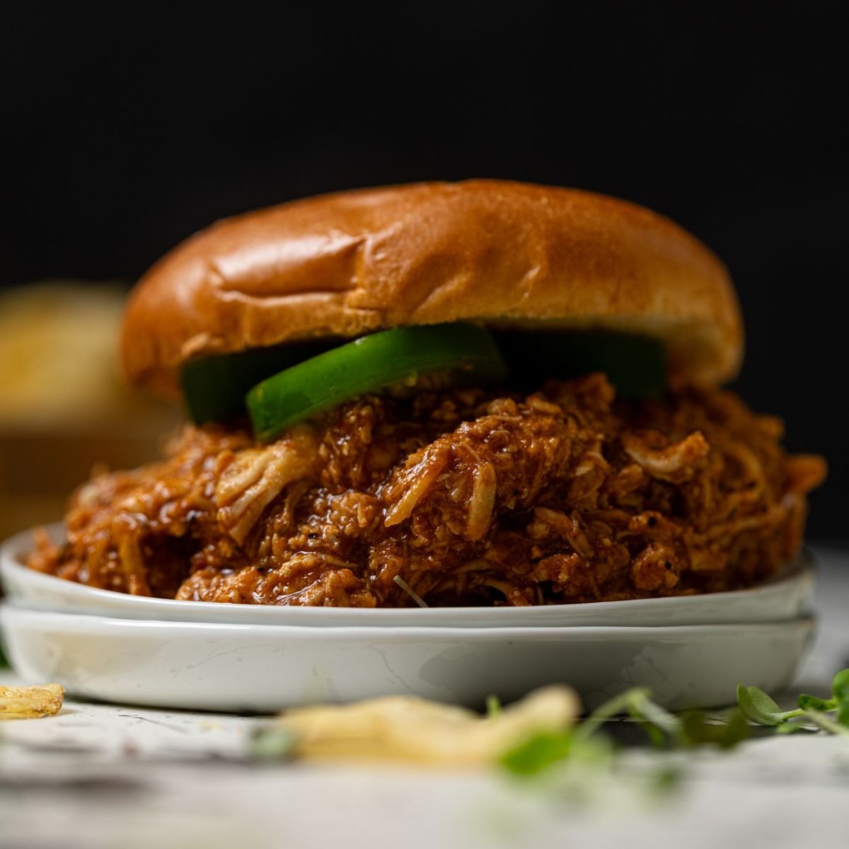 Best BBQ Pulled Chicken Sandwich on a white plate.