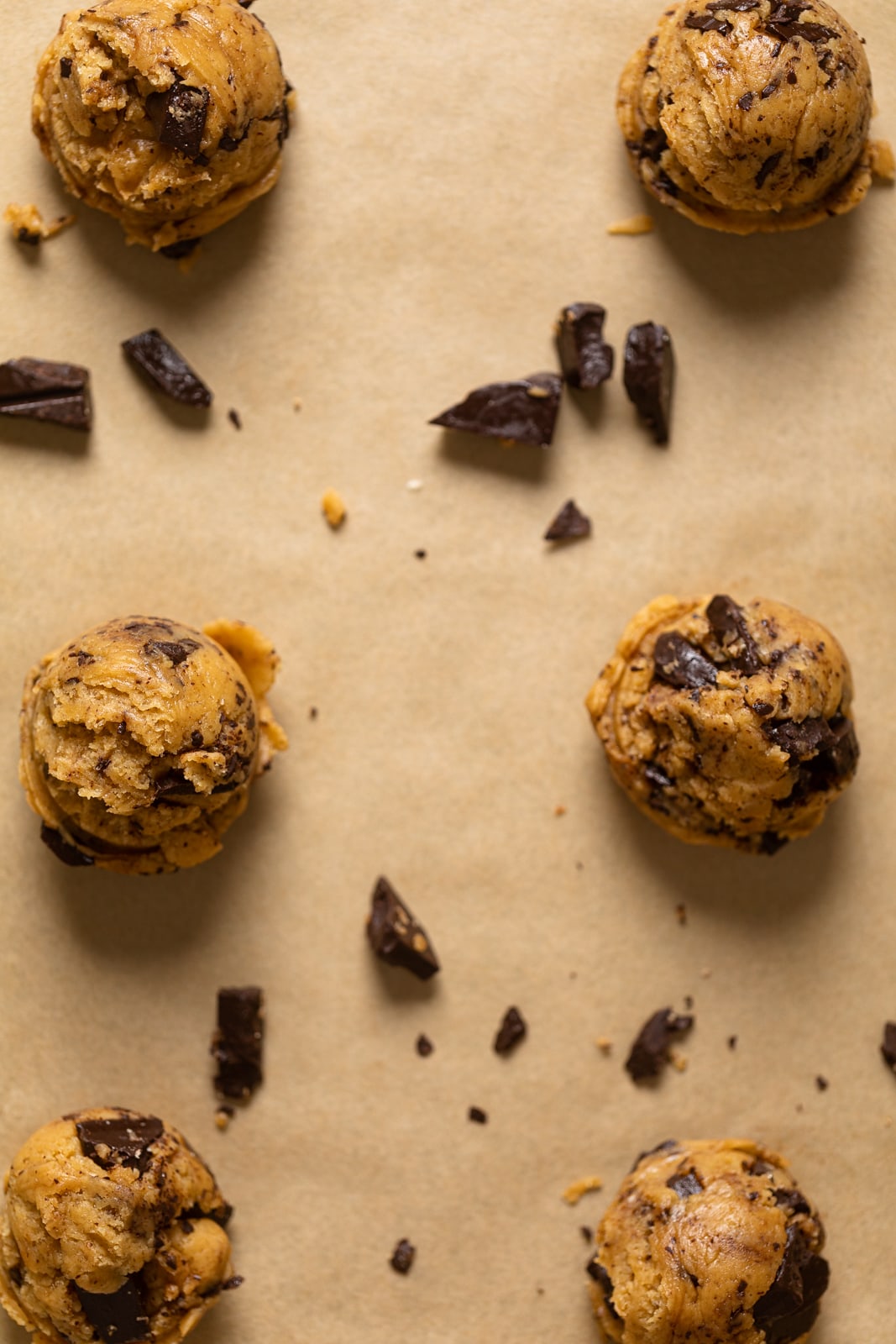 Big Brown Butter Chocolate Chip Cookie dough balls on parchment paper