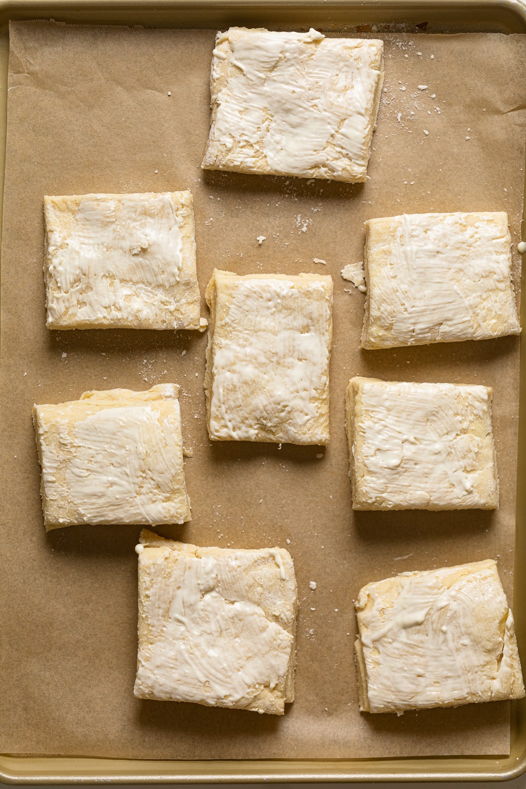 Flaky Honey Buttermilk Biscuit dough cut into rectangles and on parchment paper