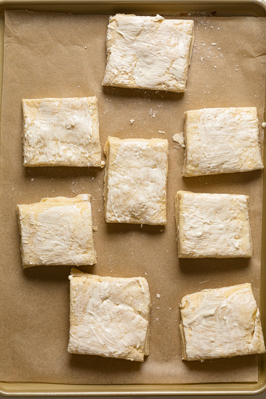 Flaky Honey Buttermilk Biscuit dough cut into rectangles and on parchment paper