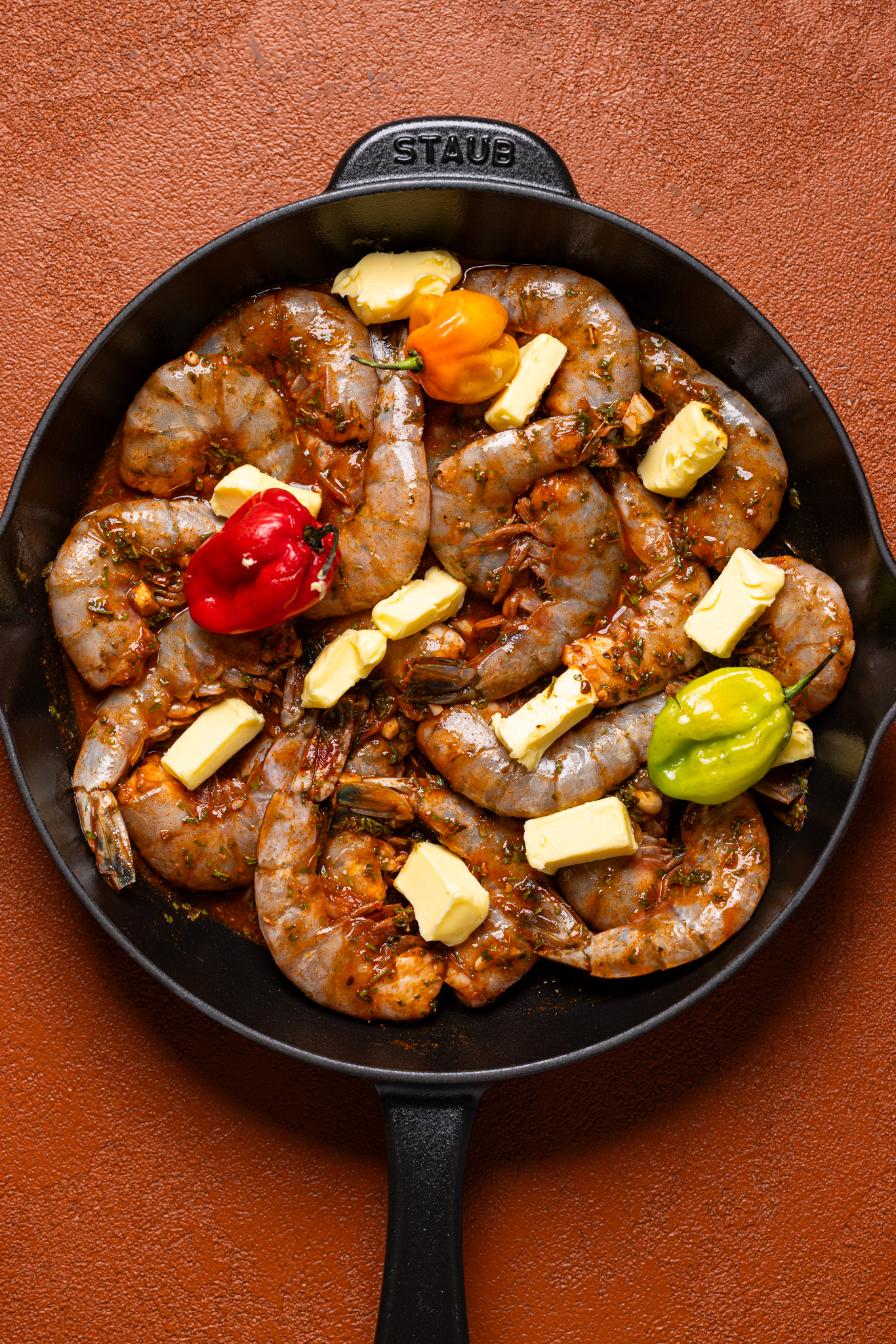 All ingredients together in a skillet on a burnt orange table.