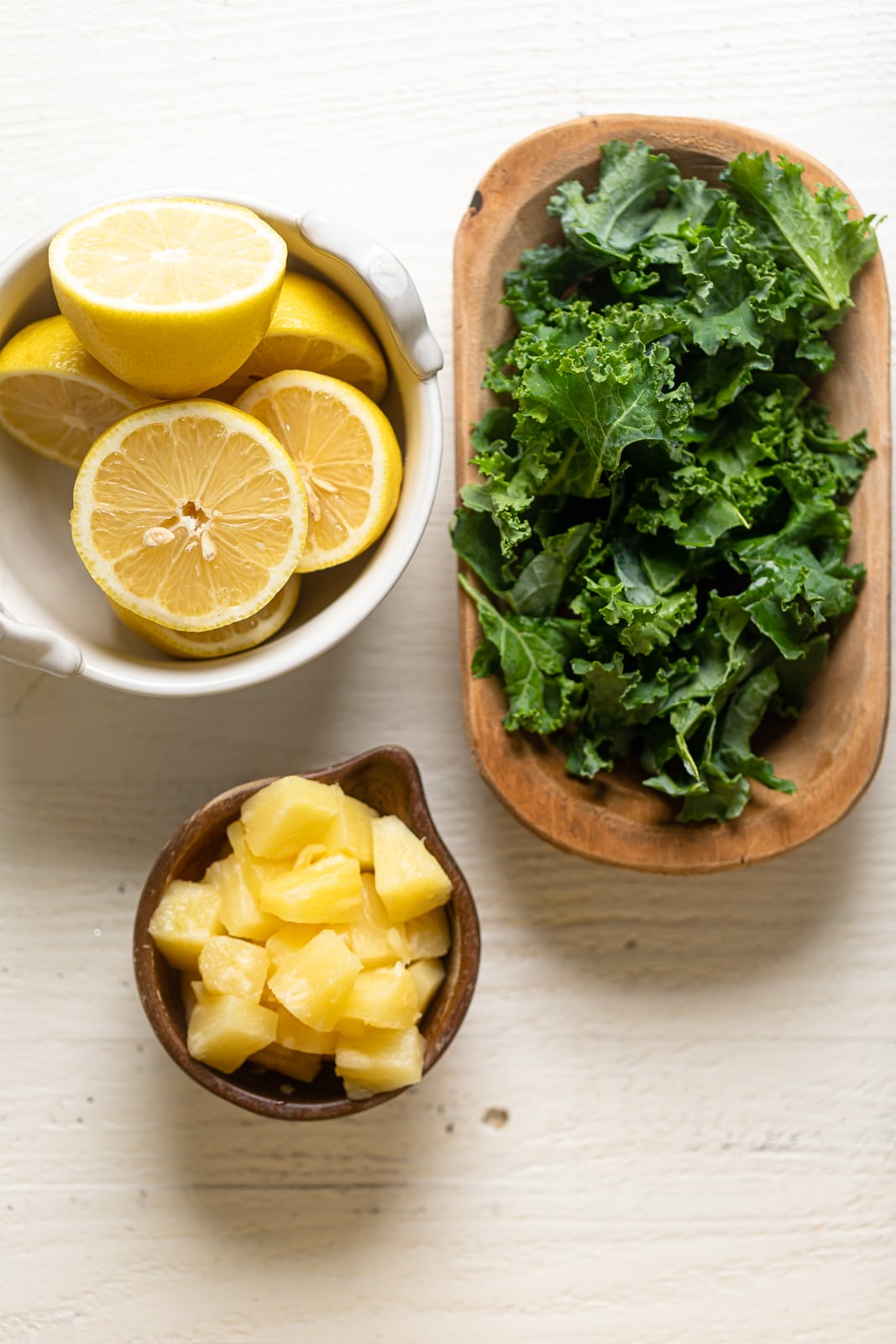 Ingredients for Kale Lemonade including kale, lemons, and pineapple chunks