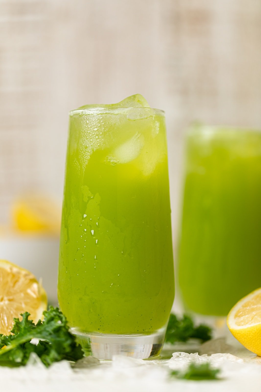 Two glasses of bright green Kale Lemonade with ice