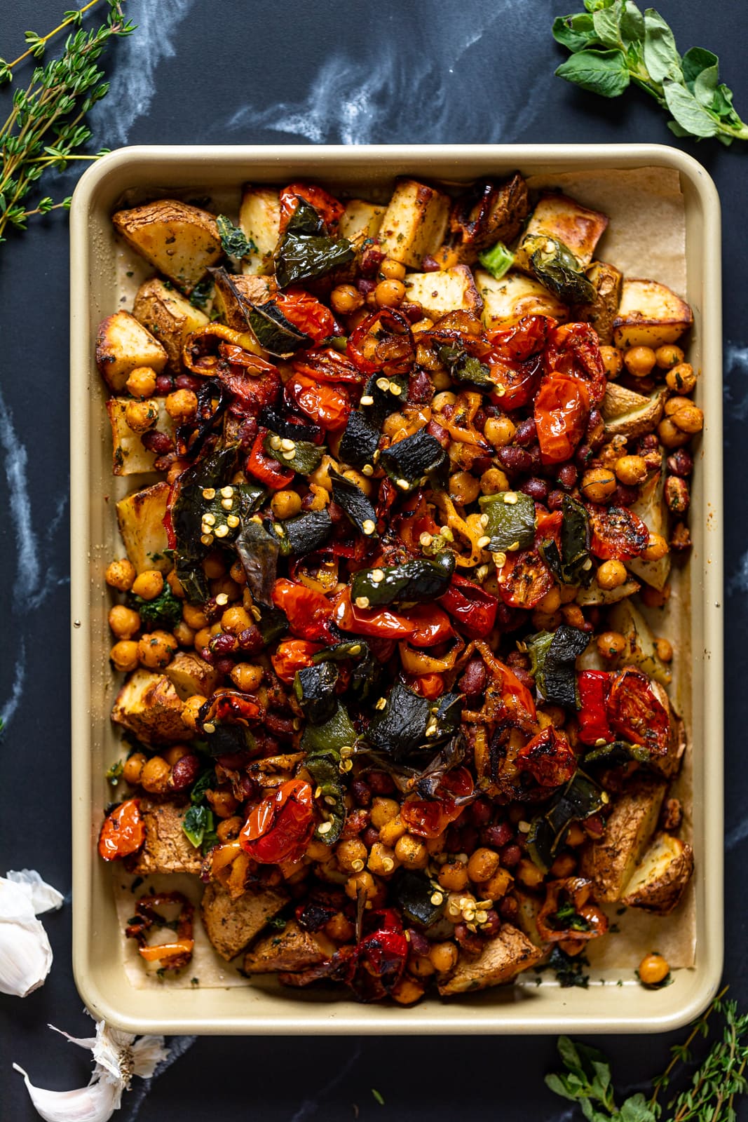 Overhead shot of a sheet pan of colorful Loaded Potatoes with Spicy Beans