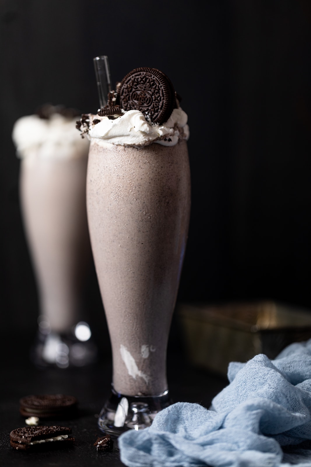 Tall glass filled with an Oreo Milkshake topped with Oreos