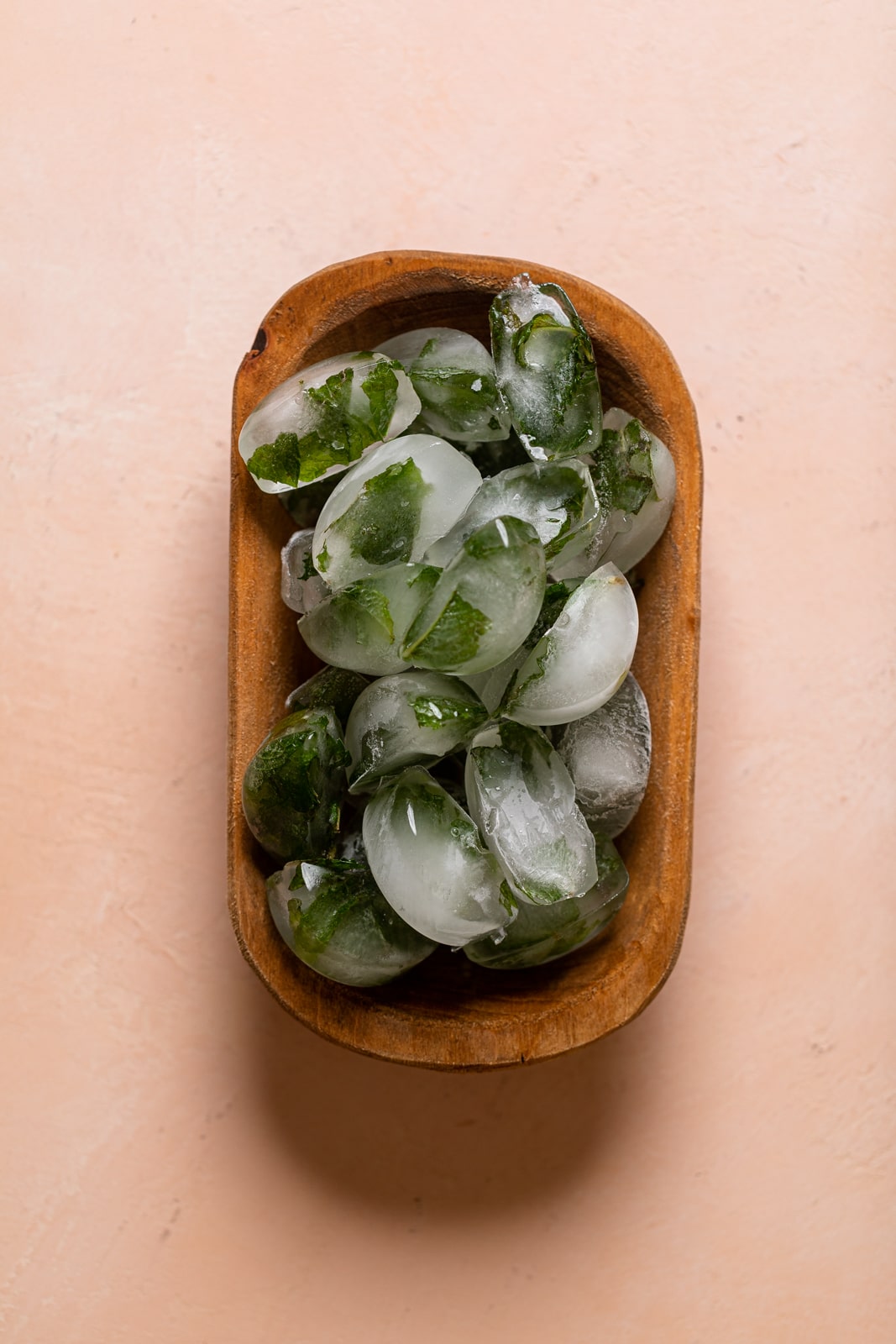 Wooden bowl full of mint ice cubes