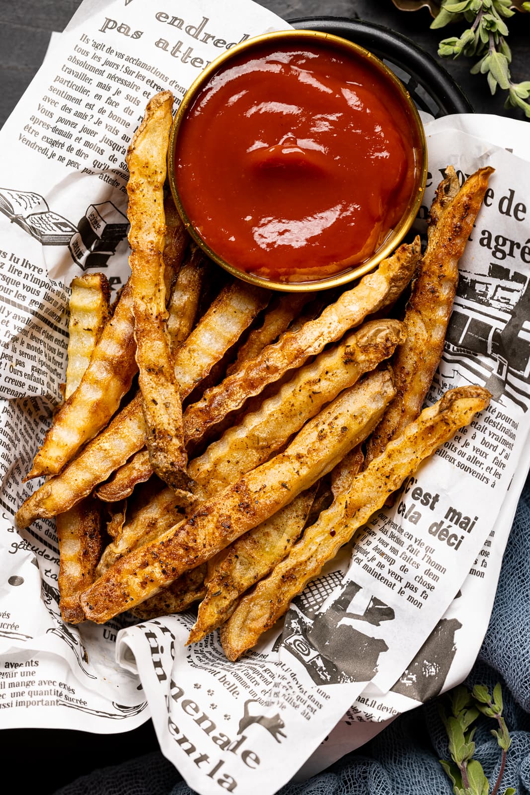 Up close shot of fries in food basket with a side of ketchup.