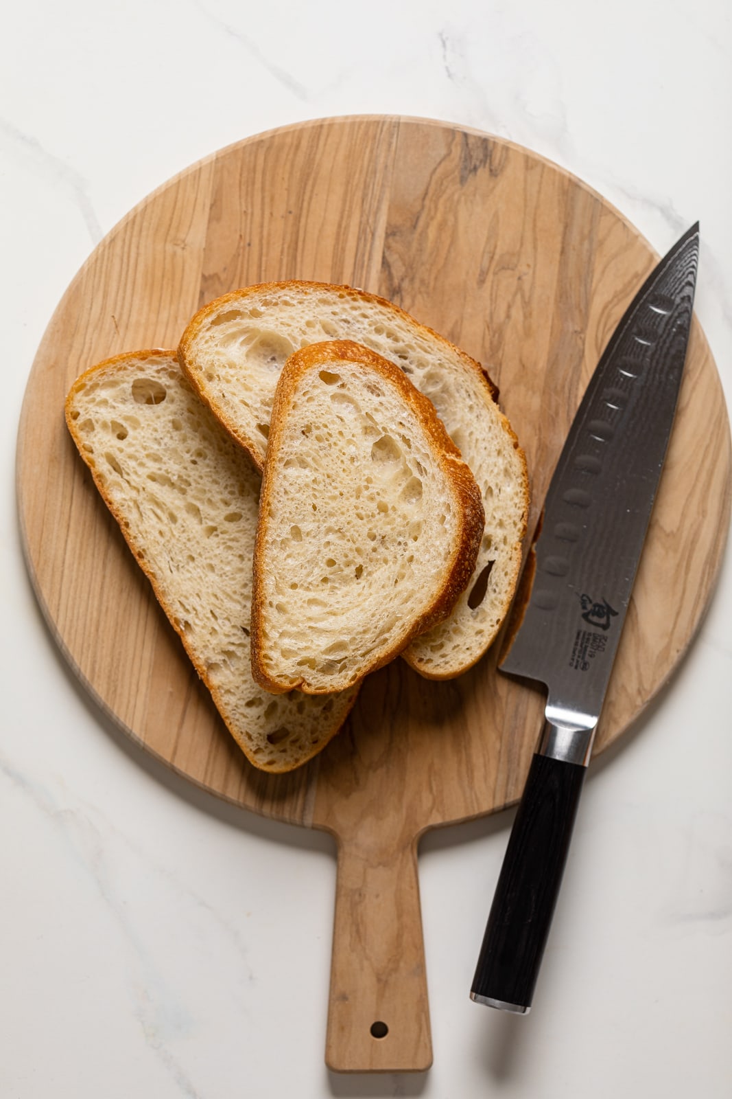 Slices of bread on a cutting board with a knife