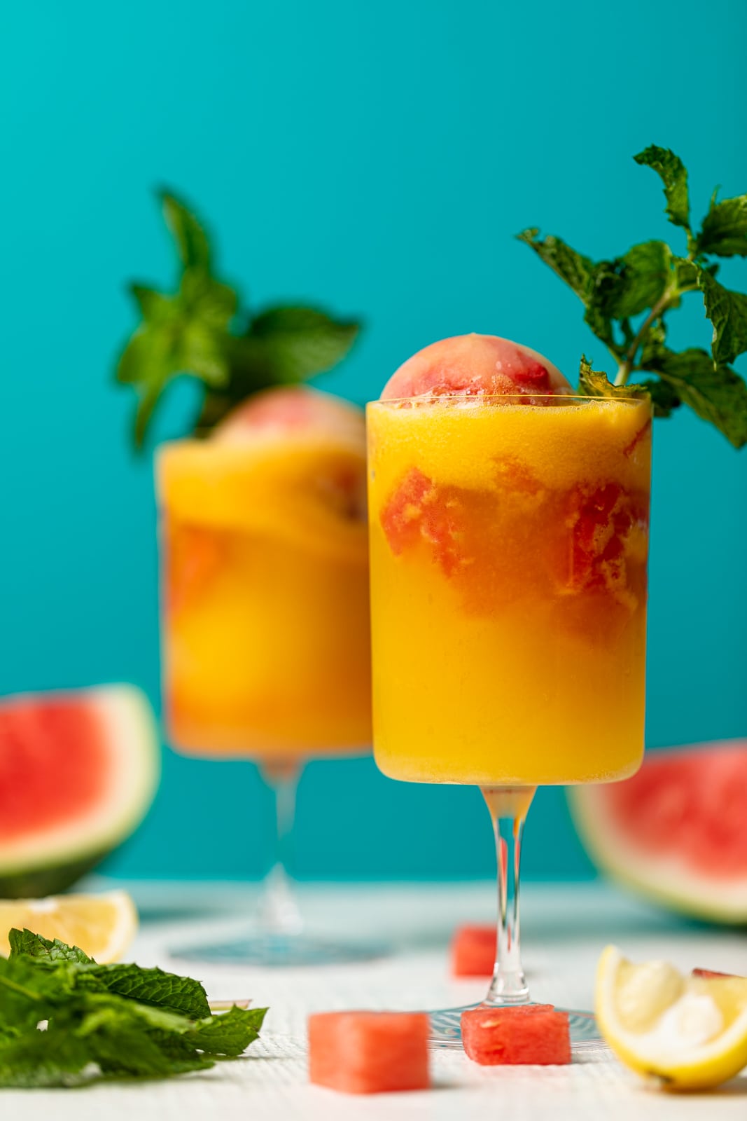 Two colorful Jamaican Me Happy Mocktails near pieces of watermelon