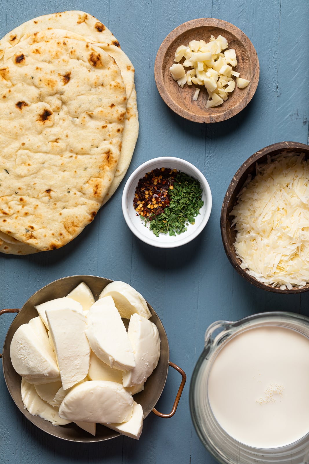 Ingredients for Everything Bagel Cheese Naan Pizza including garlic, crushed red pepper, and cheese