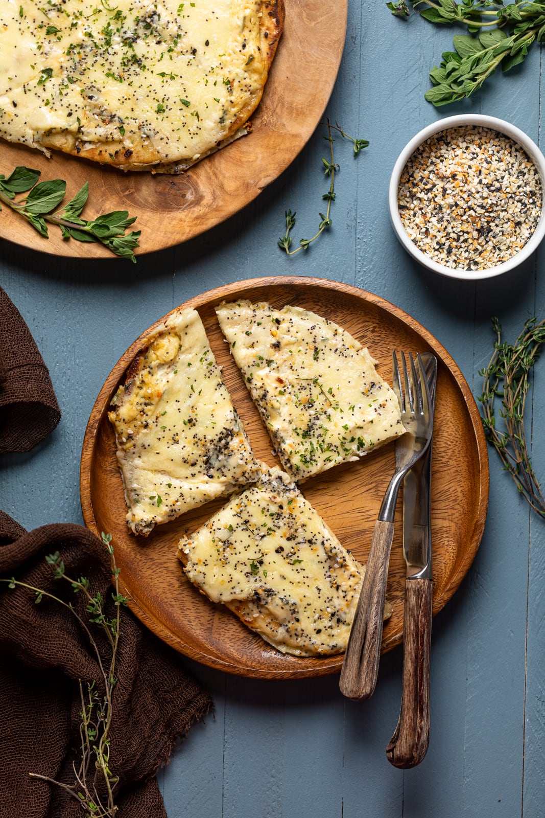 Three slices of Everything Bagel Cheese Naan Pizza on a wooden plate