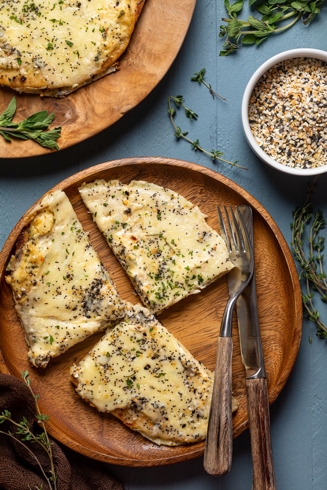 Three slices of Everything Bagel Cheese Naan Pizza on a wooden plate