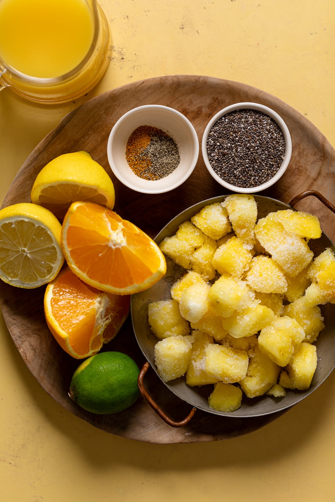 Ingredients for a Pineapple Citrus Smoothie including oranges, apples, and limes