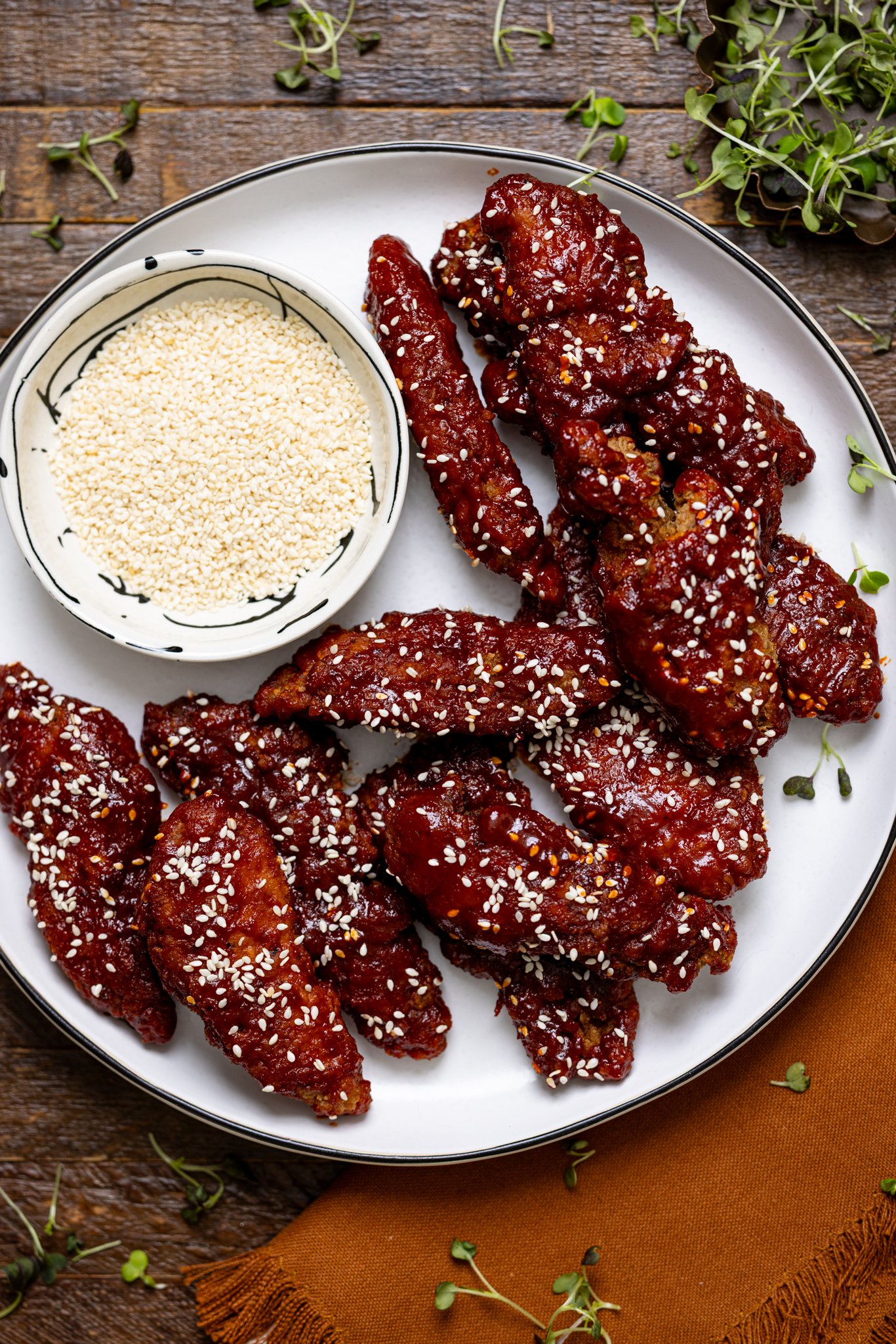 Delicious Gochujang Chicken Tenders on a platter on a wood table.