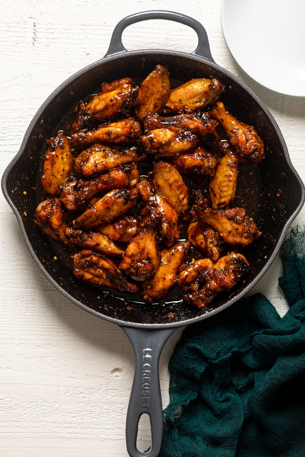 Overhead shot of a skillet of Sticky Peach Chicken Wings