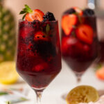 Glass full of fruit and dark red Loaded Hibiscus Mocktail