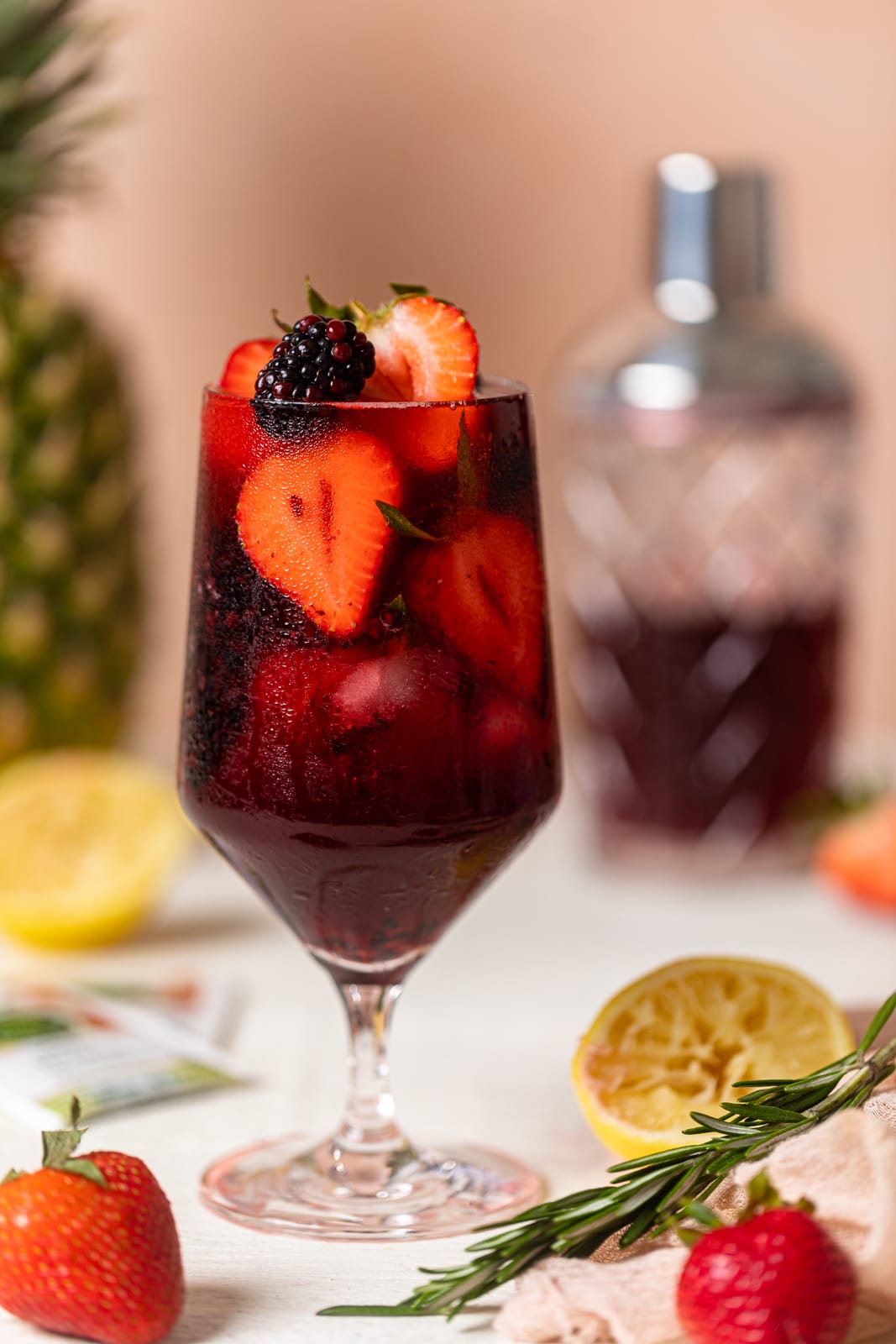 Glass full of fruit and dark red Loaded Hibiscus Mocktail