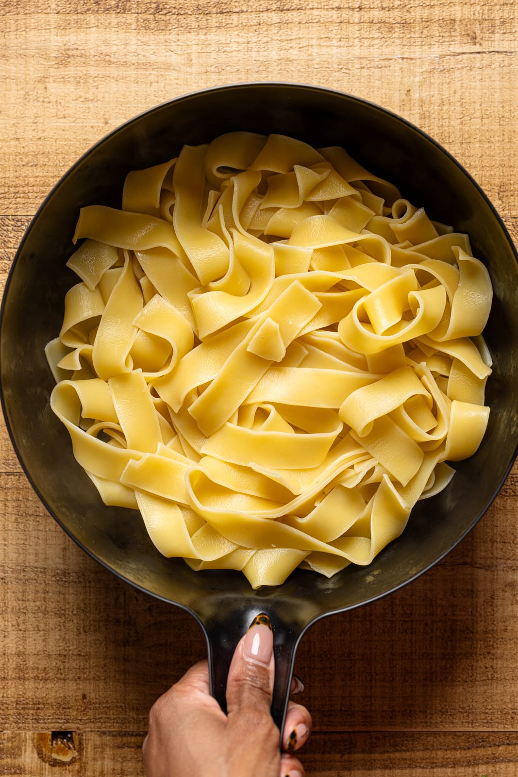 Drained cooked pasta in a coriander. 