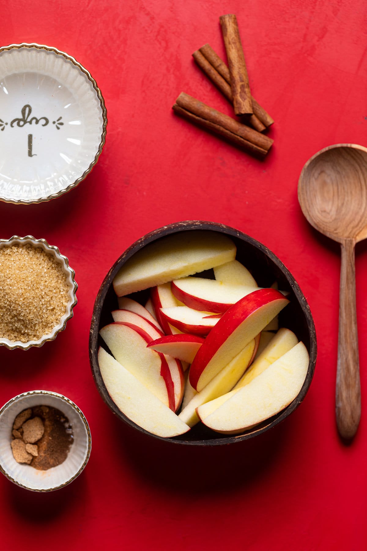 Ingredients for Apple Crisp Oatmilk Latte including cinnamon sticks, apple slices, and sugar