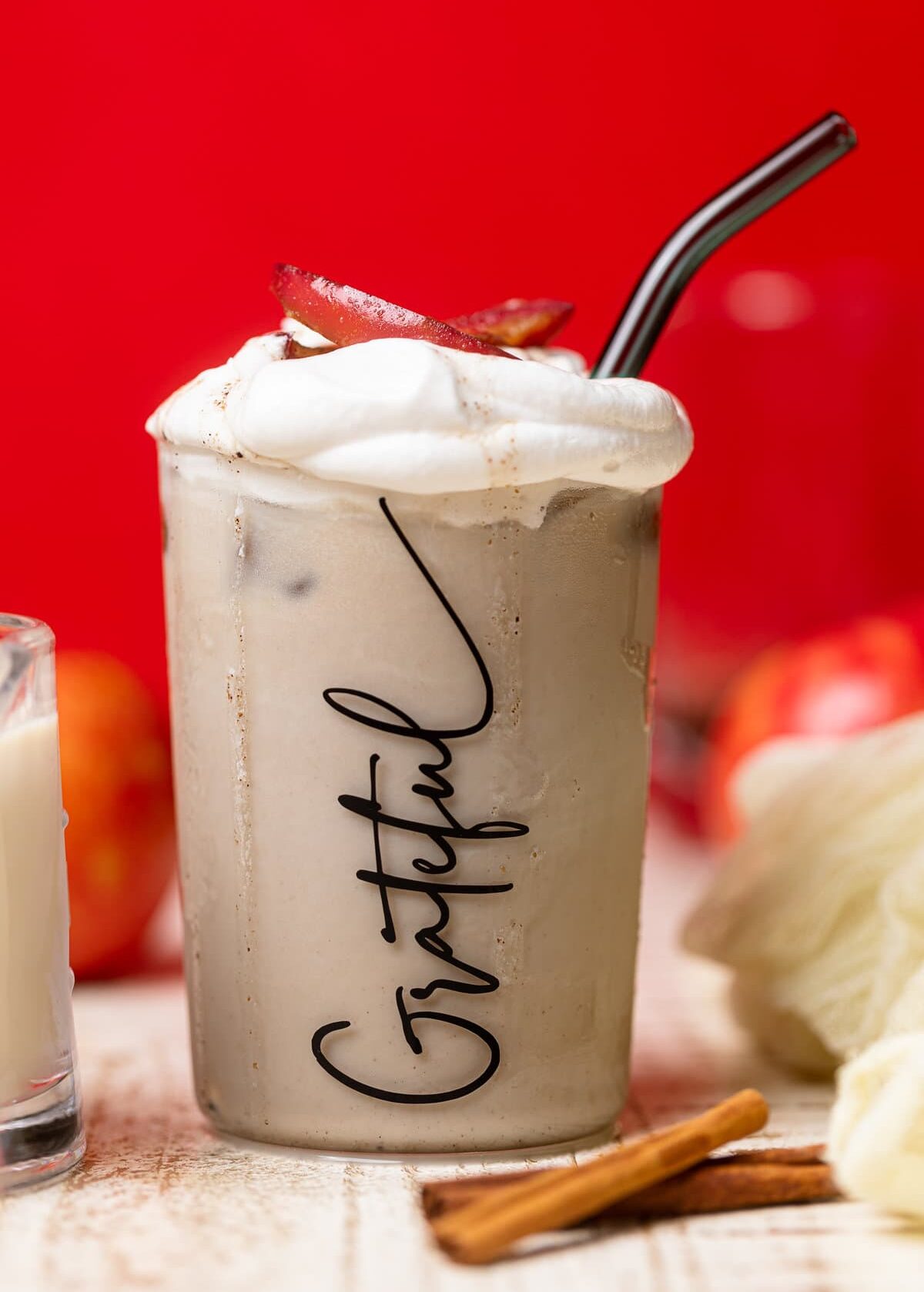 Apple Crisp Oatmilk Latte in a glass that has "Grateful" written on it