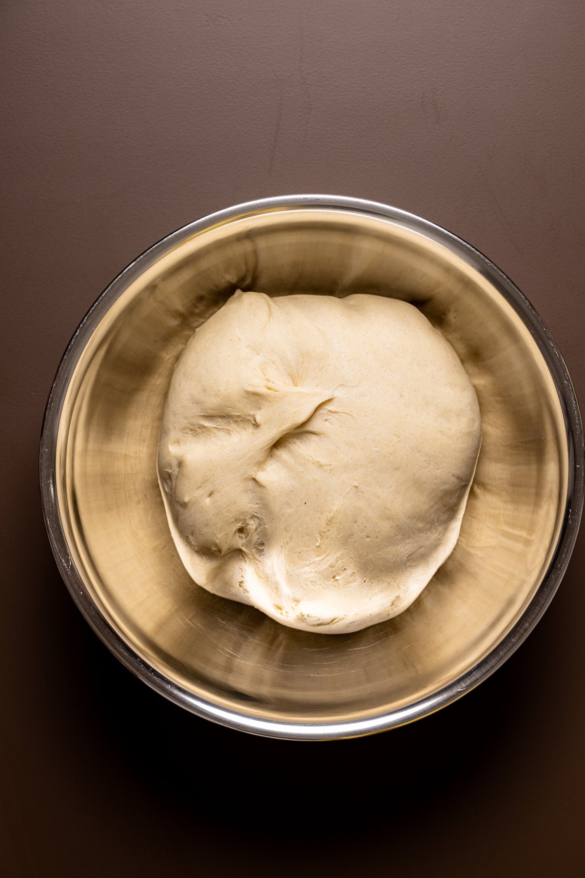 Ball of pizza dough in a metal bowl