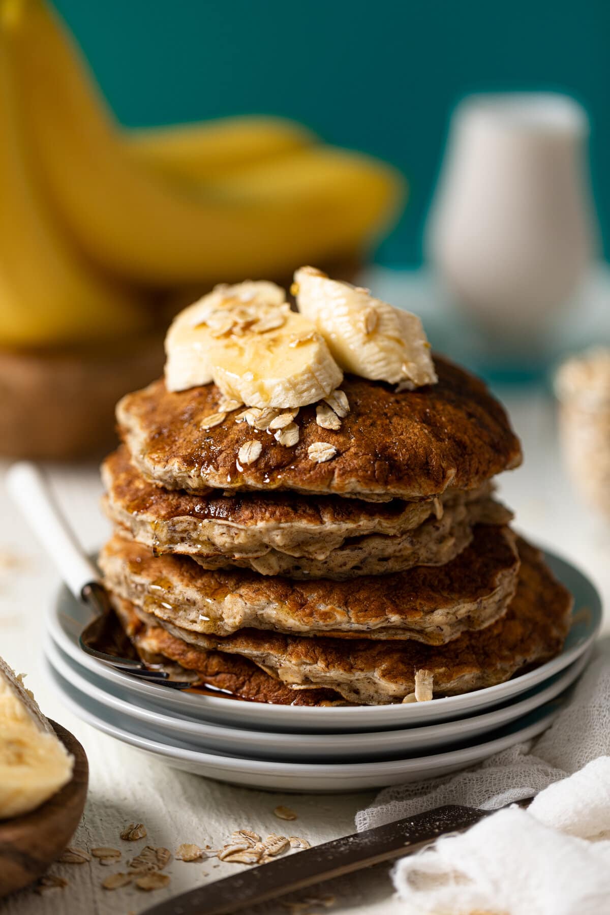 Stack of Fluffy Banana Oat Pancakes with a fork