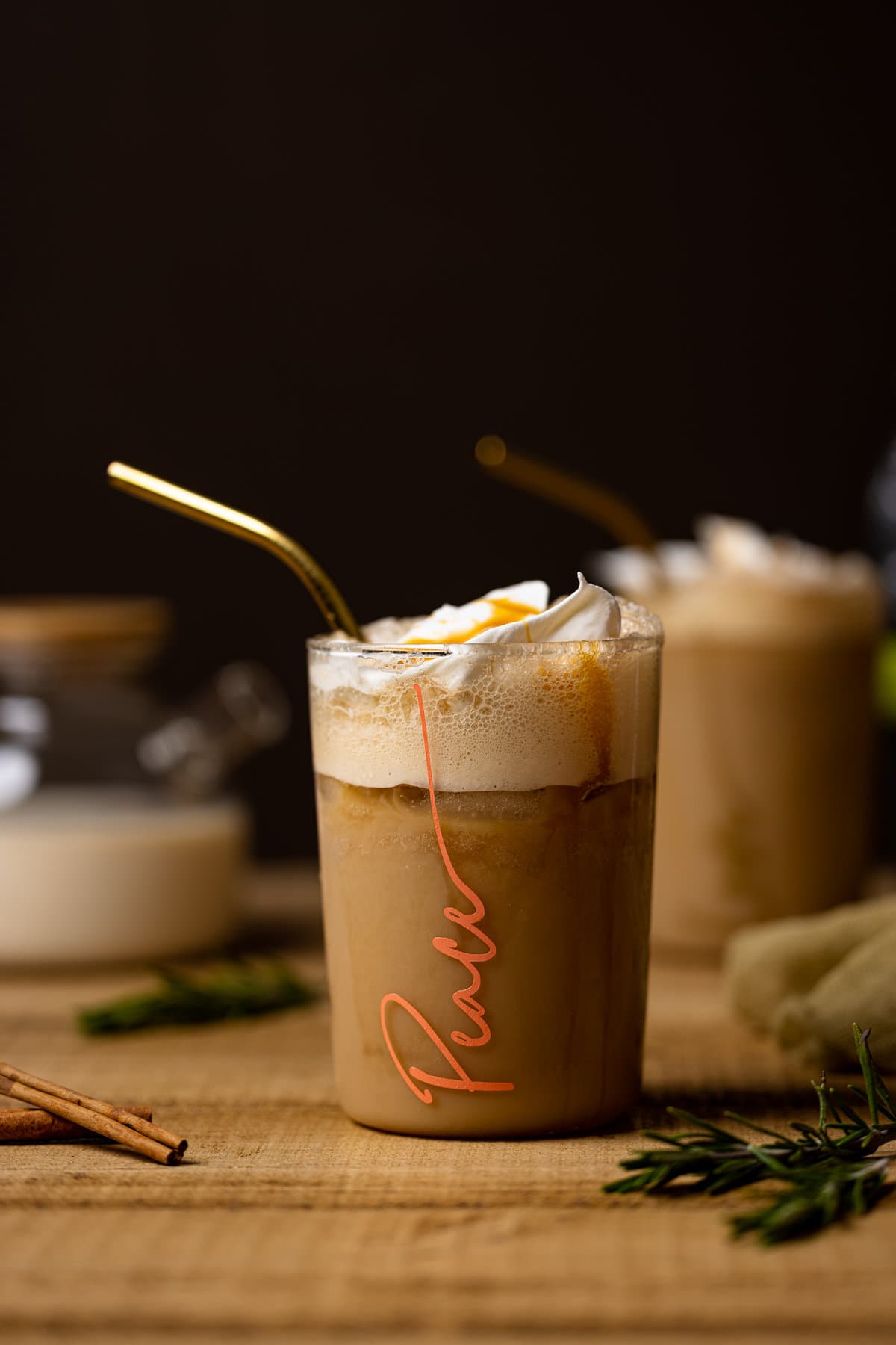 Iced Brown Sugar Shaken Espresso with a straw in a glass with \"Peace\" written on it